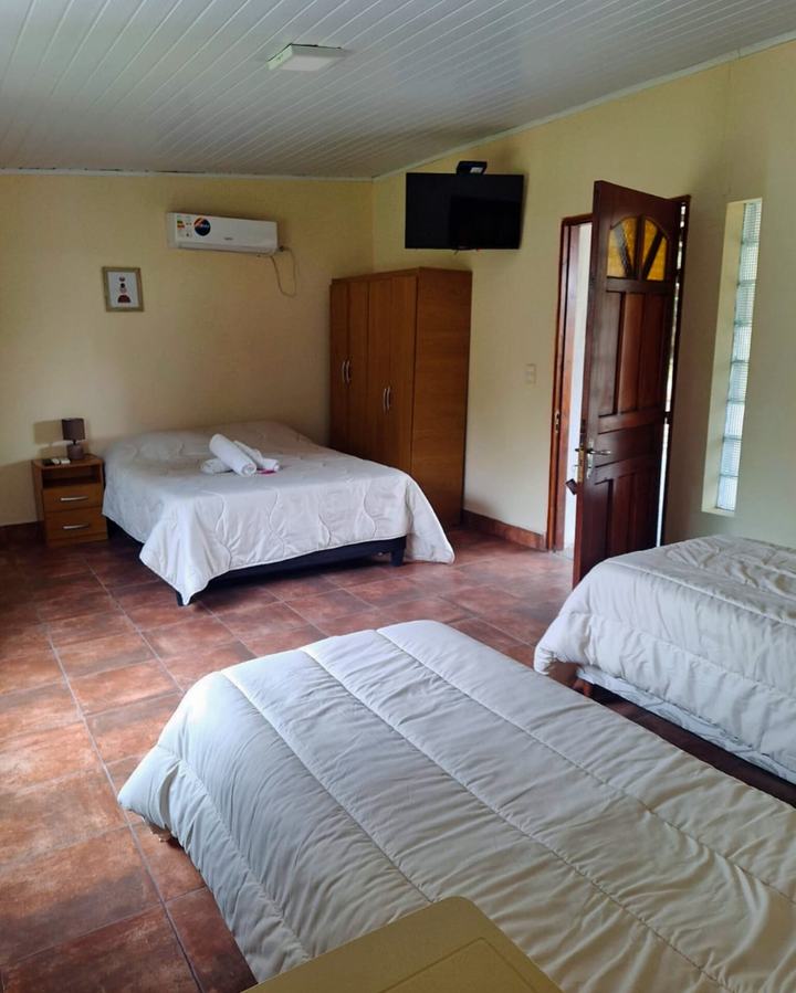 Habitación cuádruple con cama matrimonial, dos camas single, TV y aire acondicionado
