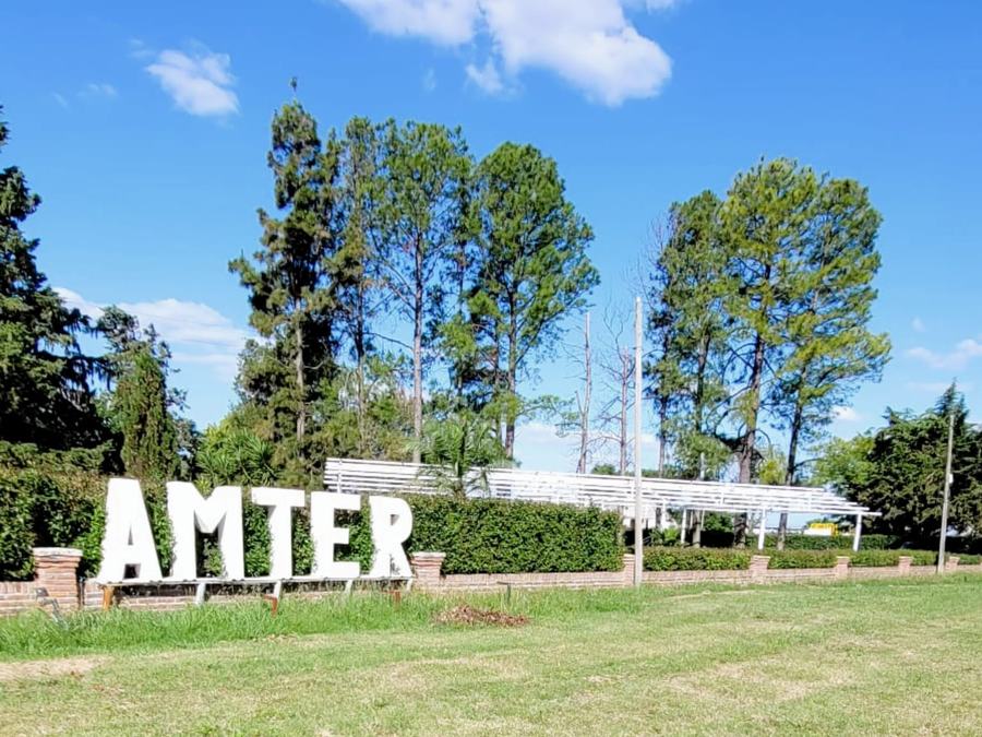 Letras de AMTER en la entrada, entre árboles y cielo azul