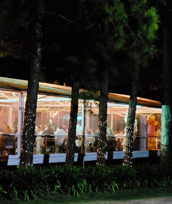 Salón de fiestas iluminado entre pinos
