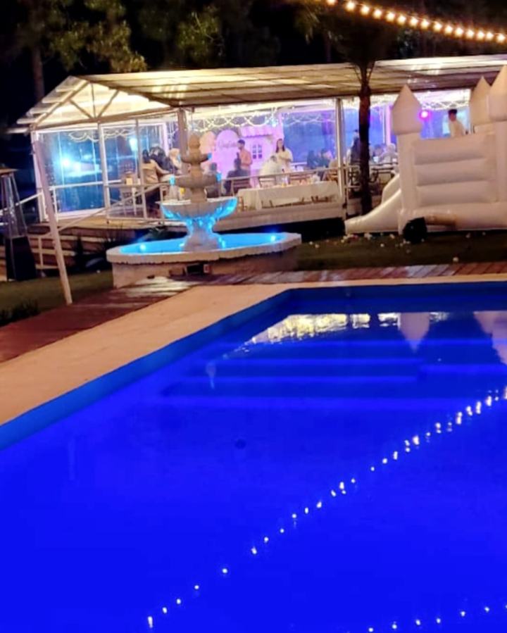 Piscina iluminada frente al salón de eventos