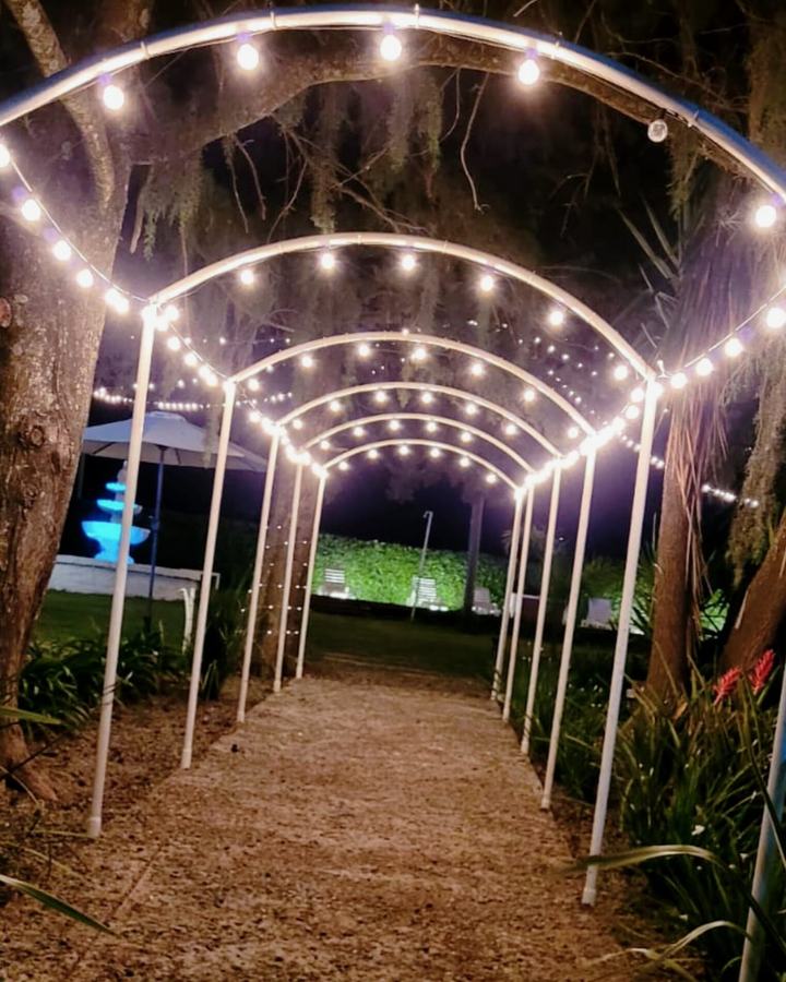 Pasillo de arcos con luces cálidas en el jardín