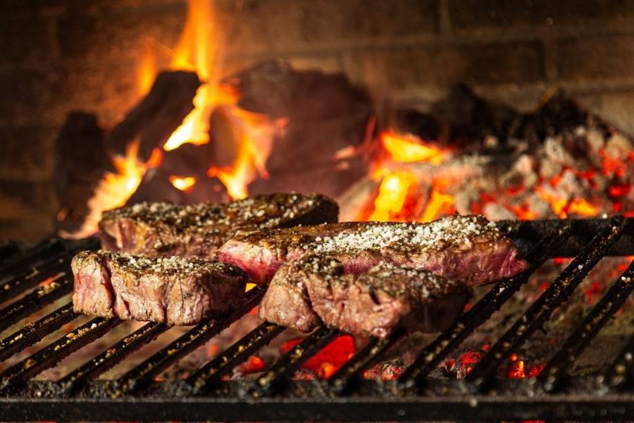 Cortes de carne a la parrilla sobre brasas y leña