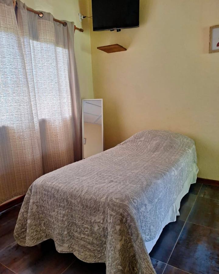 Cama single junto a la ventana, con TV